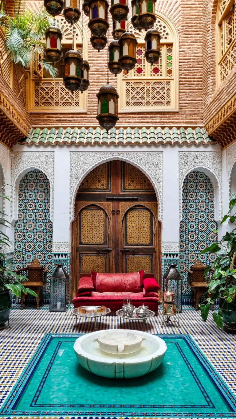 Traditional Moroccan riad courtyard with fountain and zellige tiles, evoking the Fes medina riads
