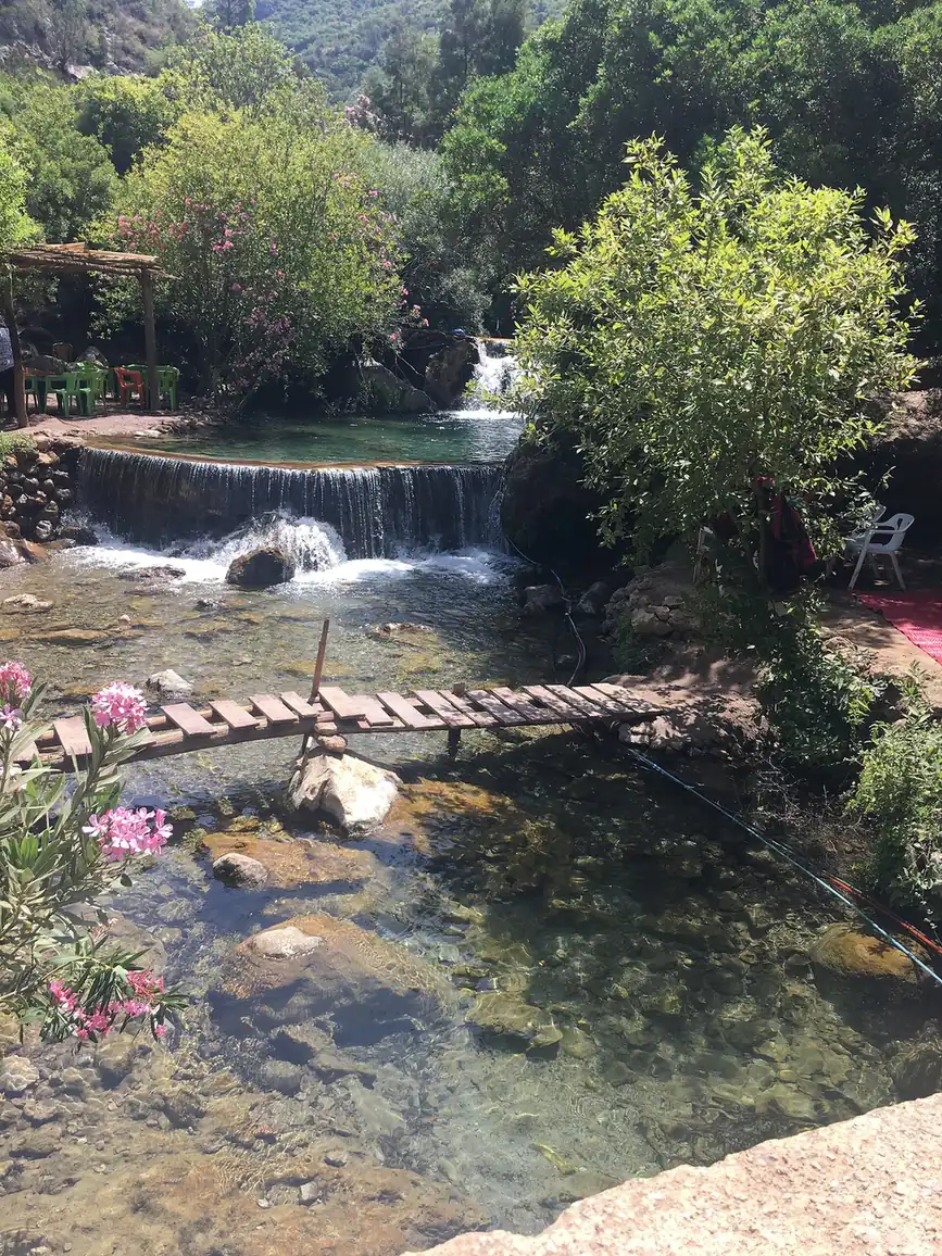 Cascade and clear rock pools with a wooden footbridge at Akchour in the Talassemtane hills